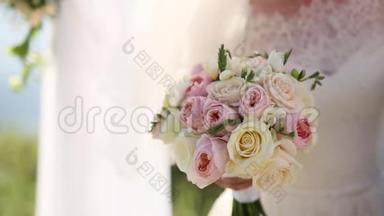 新娘手中的婚礼玫瑰和牡丹。 婚礼